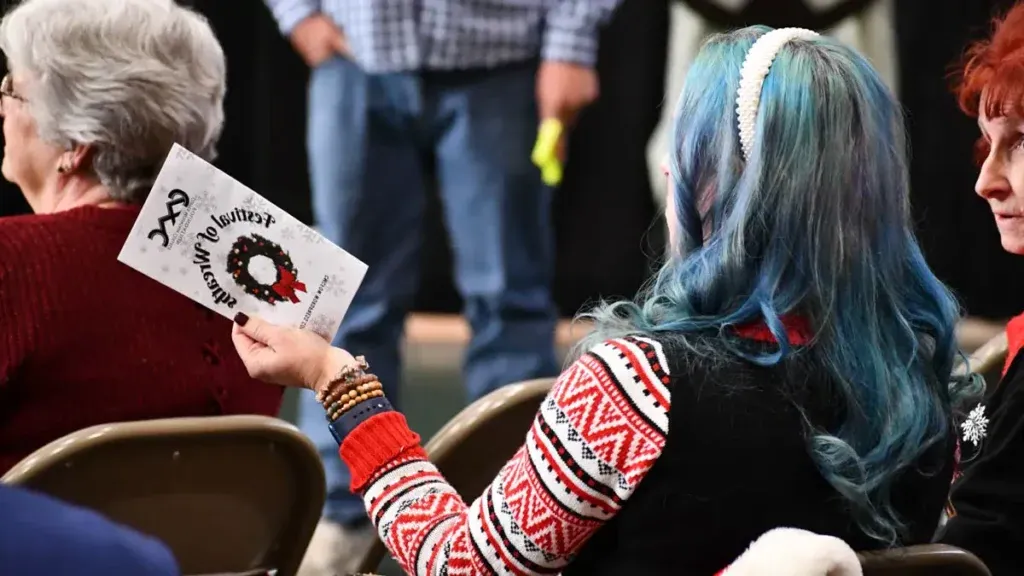 woman holding a CMC Festival of Wreaths pamphlet